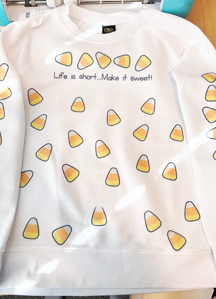 Professional sewing machine on wooden table near chair at wall with drafts of clothes and samples of textile in atelier