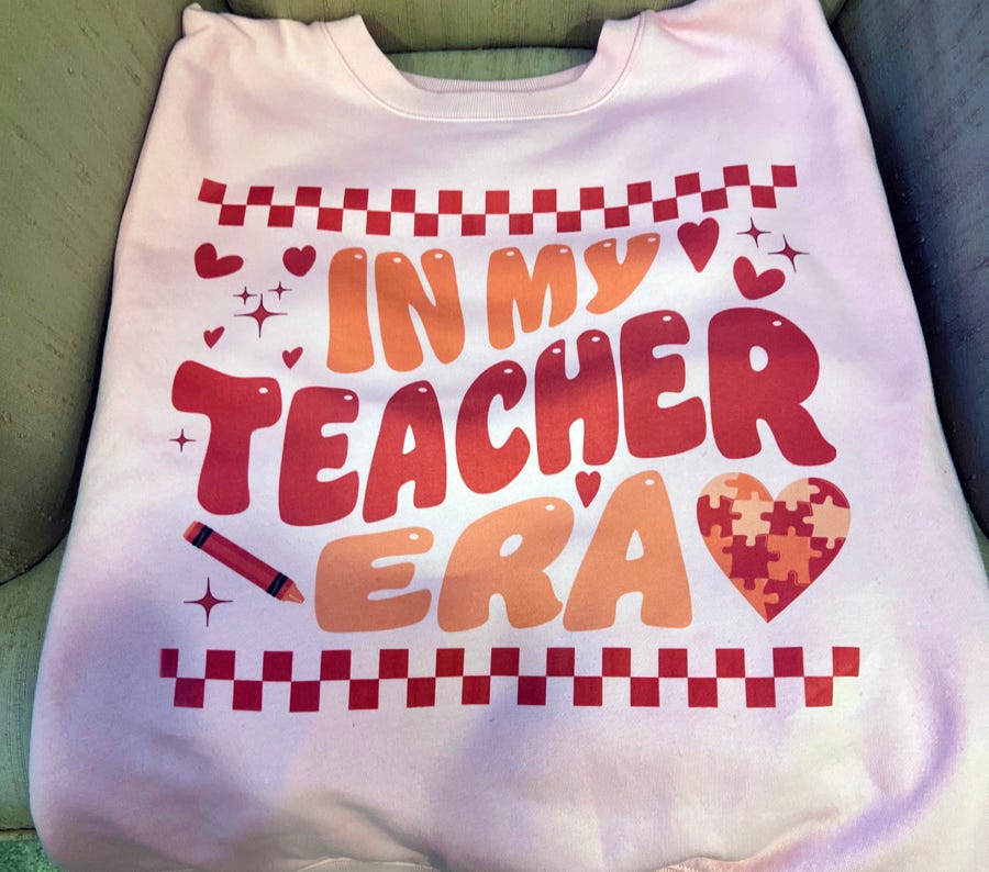White table with chairs of unique shape placed near wall niche with black ceramic vases under crystal vintage chandelier in spacious light room with white walls and wooden floor